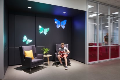 This recessed waiting area features DIRTT's solid modular walls with integrated custom light graphics.