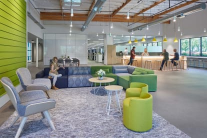 A beautiful open office space uses DIRTT's modular solid and glass walls to divide working and casual areas.