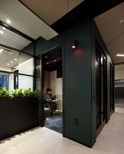 This private phone booth area has a center mount glass wall to let in natural light.