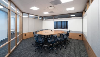 Inside this meeting room are combination glass and solid modular walls, integrated tech, and writeable surfaces.