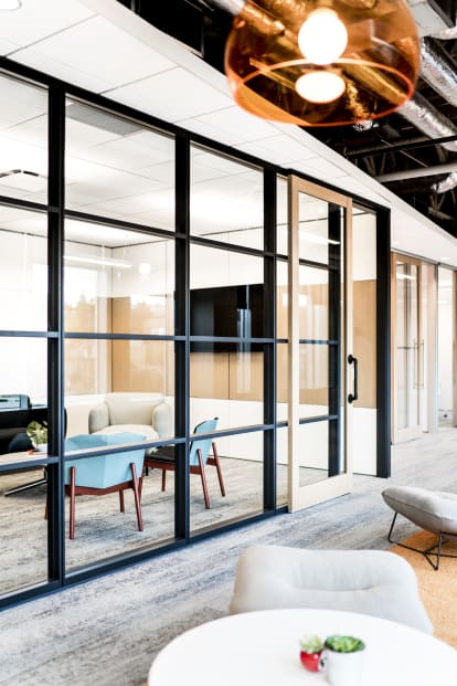 From the hallway we see a stacked modular glass wall and aluminum framed sliding glass door from DIRTT.