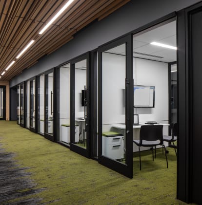 University student building with meeting spaces behind sliding glass walls and integrated technology