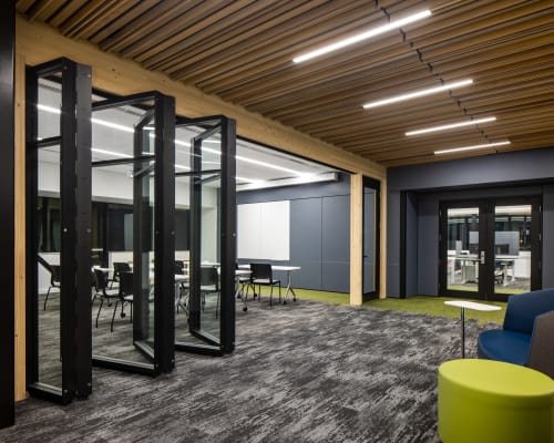 College student center with folding walls dividing rooms underneath timber ceiling