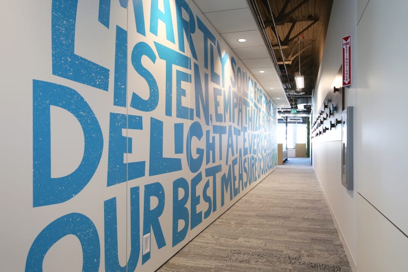 This hallway is lined with a sold modular DIRTT wall that features colorful custom graphics.