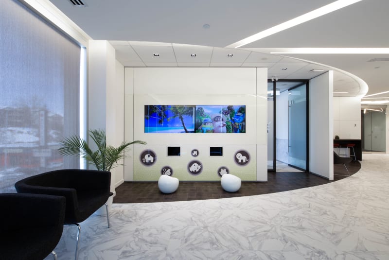 A waiting area features a solid modular DIRTT wall with custom graphics and integrated technology for children.