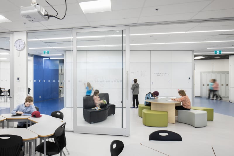 K-12 school with bright finishes around metal sliding doors with glass