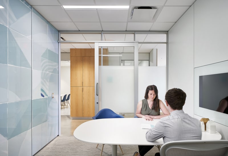 Inside this meeting space made from DIRTT's modular glass and solid walls are custom graphics and integrated technology.