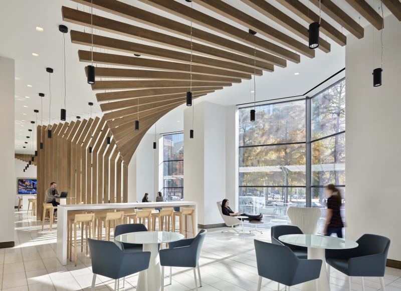15 foot Timber beams are used as sculptural wall art that looks like a wave to divide open space.