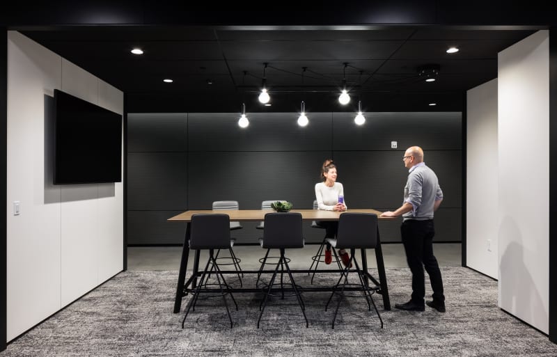 Freestanding DIRTT modular solid walls are used to mount technology is this meeting space.