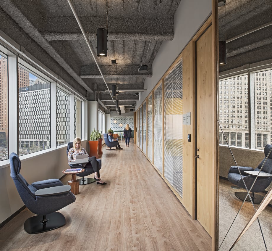 DIRTT's modular center mount glass walls and solid butt hinge door separate meeting rooms from hallway seating.