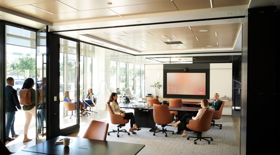 This meeting room opens up to adjacent space with a Leaf folding glass wall from DIRTT.