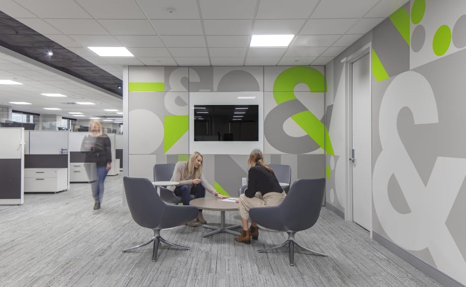 Modular solid walls shown with graphic wall panels and integrated technology shown in a collaborative office space