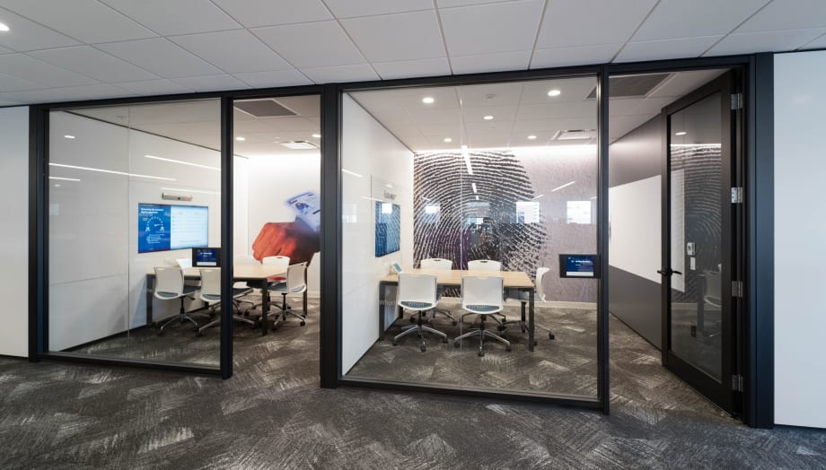 Image of an interior glass wall swinging door with a clean black frame around the exterior