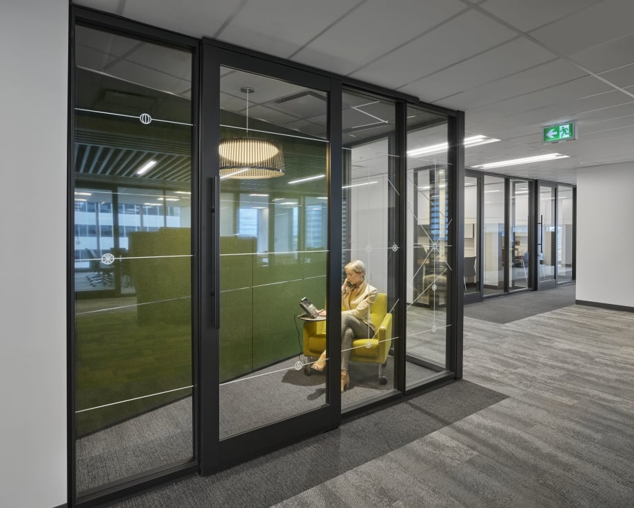 A modular phonebooth in a workplace built for speech privacy.