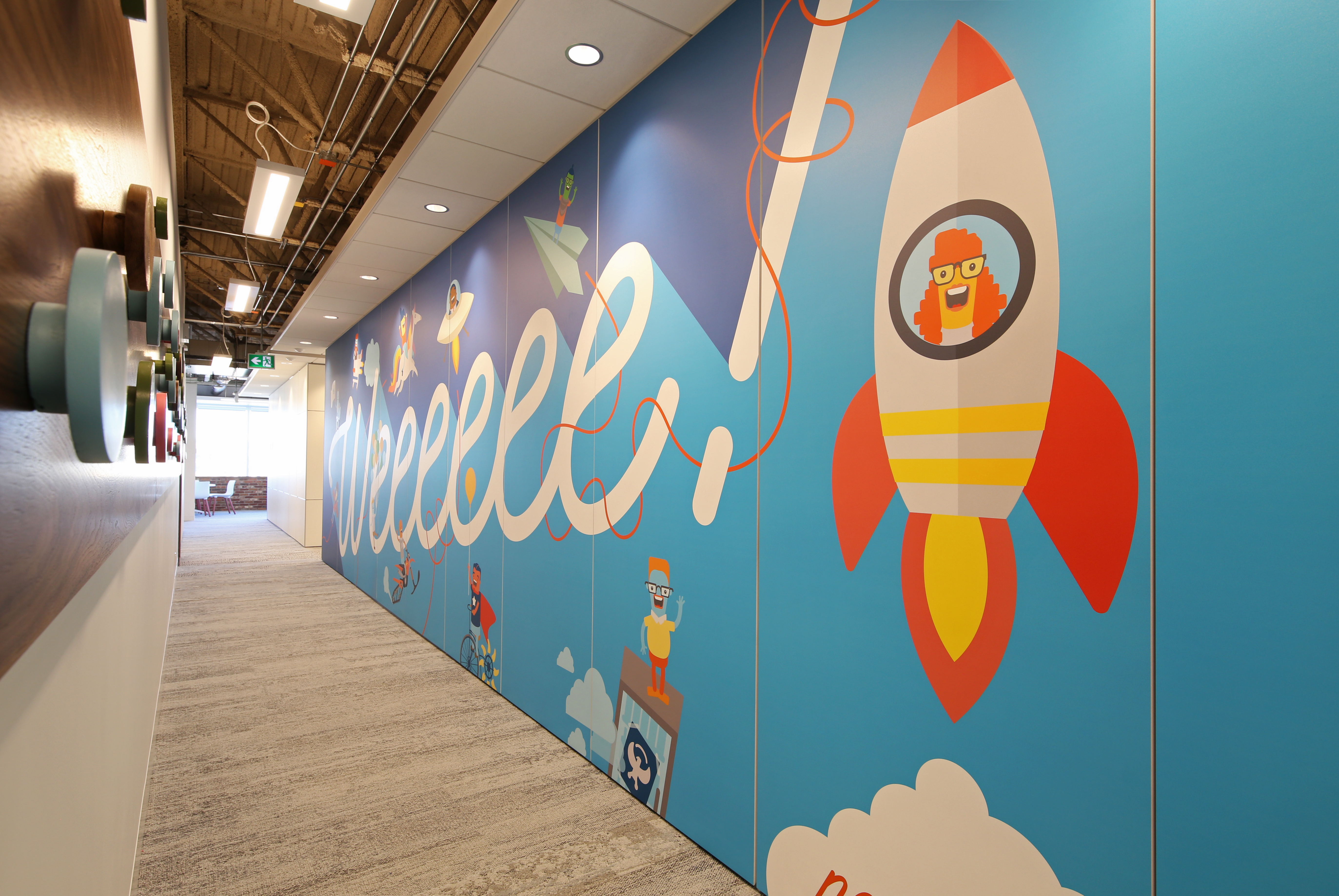 This hallway is lined with a sold modular DIRTT wall that features custom graphics.
