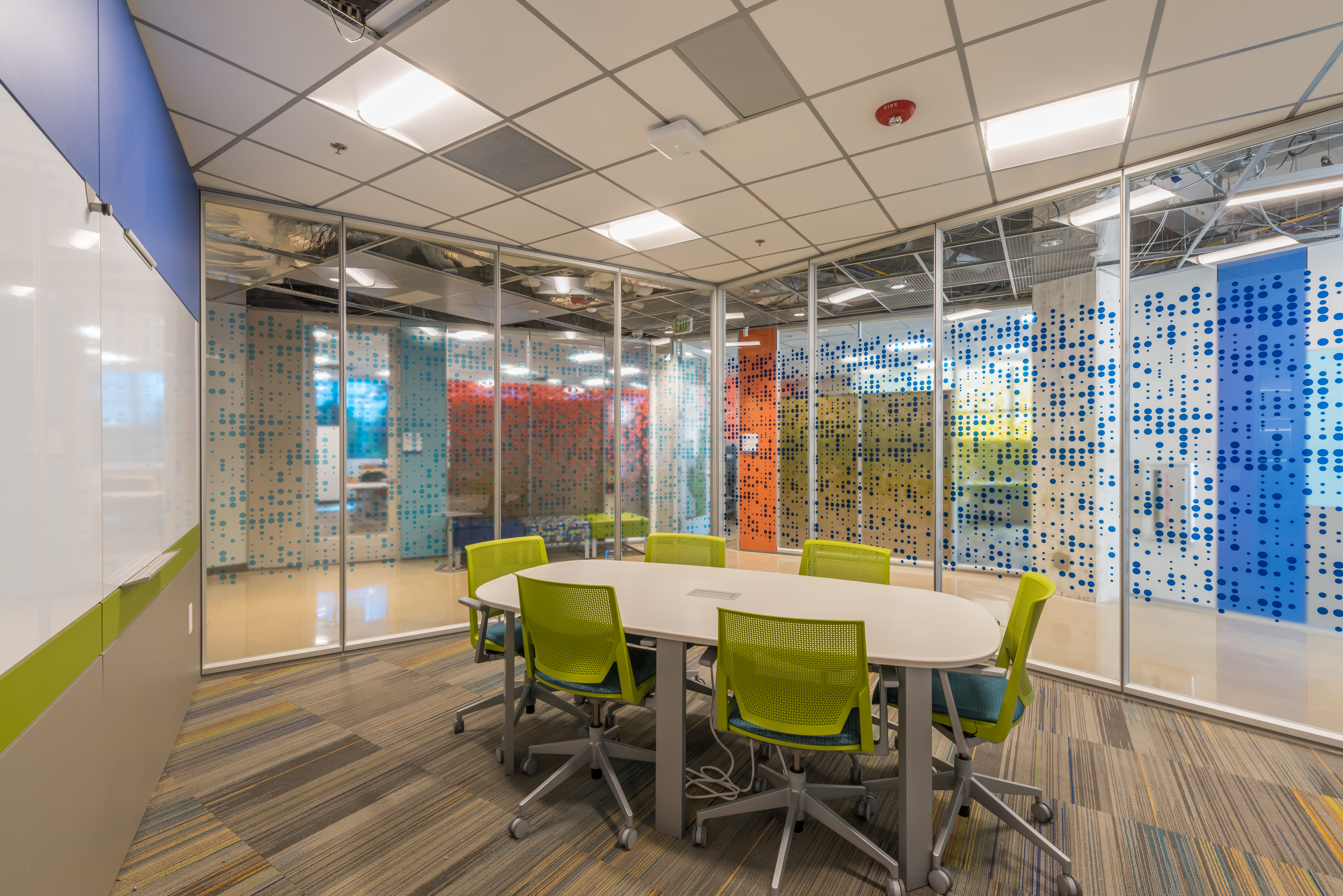 Training center meeting room with glass walls, clear finish, and modern custom graphics