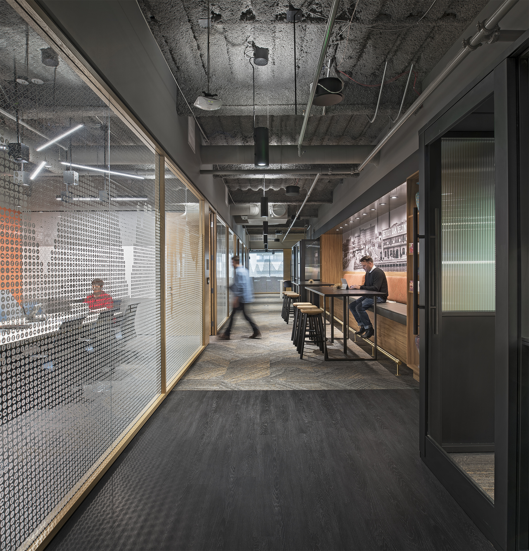 DIRTT's center mount modular glass wall features a custom graphic and divides a hallway workspace and a meeting room.
