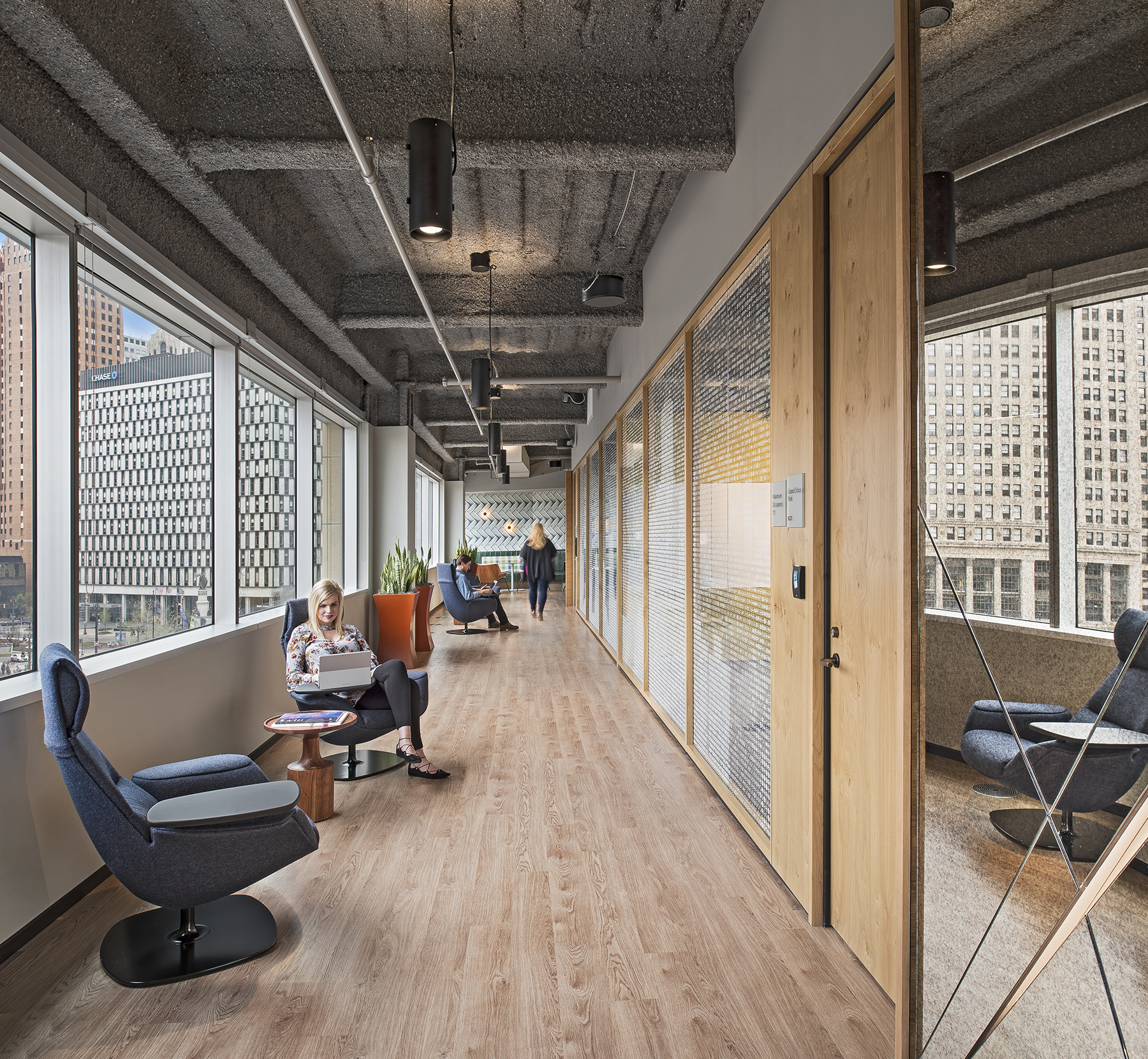 DIRTT's modular center mount glass walls and solid butt hinge door separate meeting rooms from hallway seating.