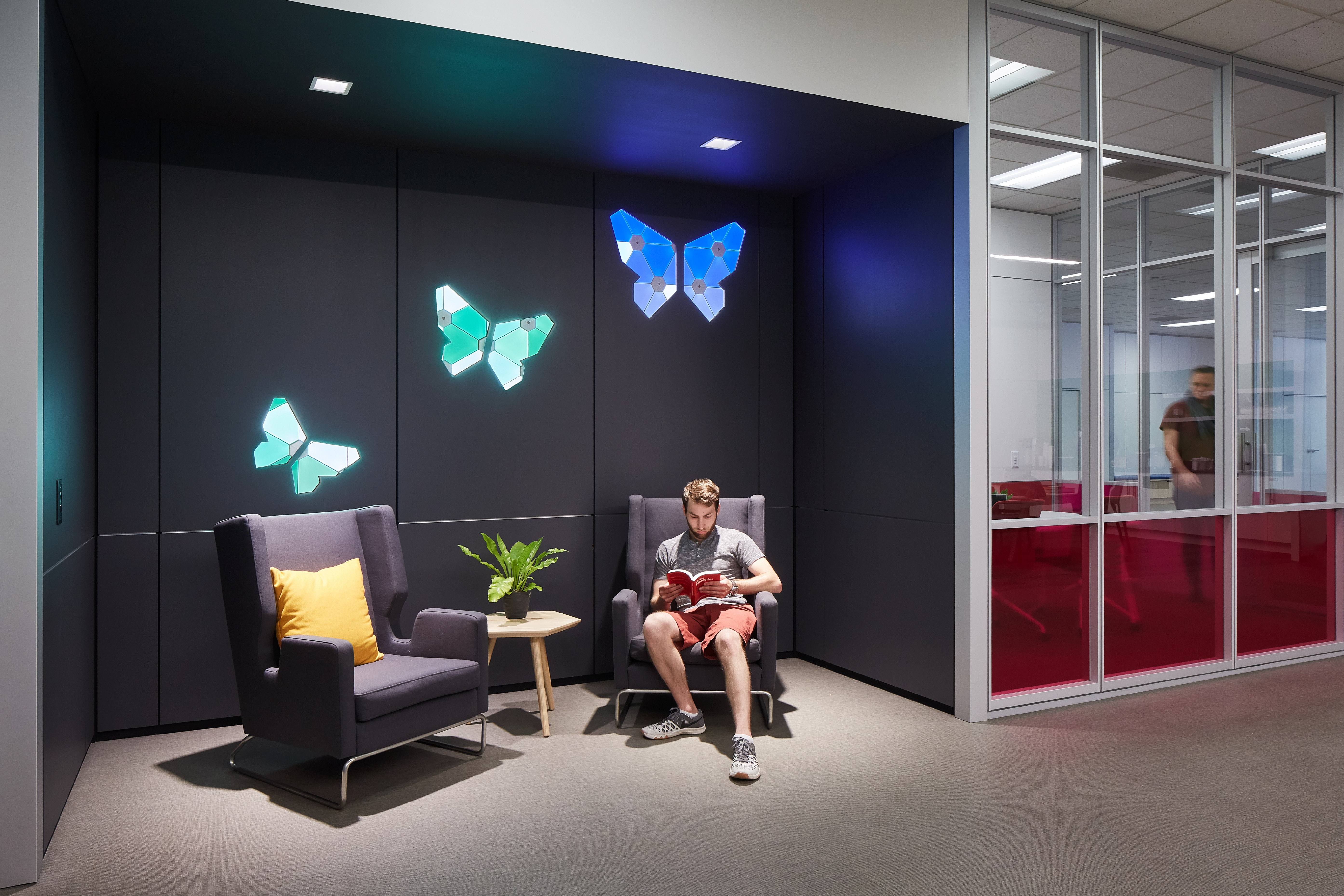 This recessed waiting area features DIRTT's solid modular walls with integrated custom light graphics.