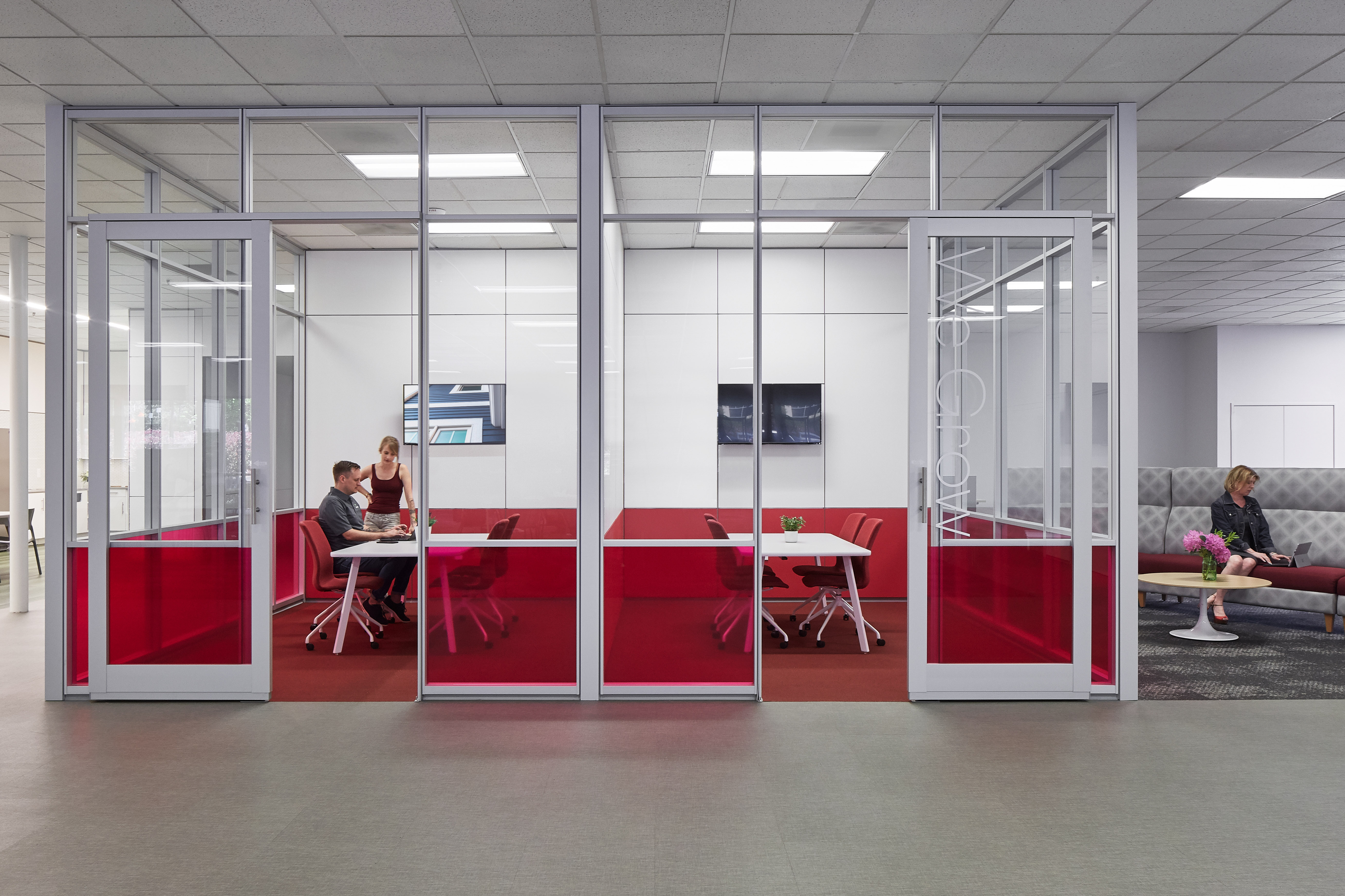 Enclosed by DIRTT's glass walls with custom graphics and solid modular walls, this freestanding pod has two meeting areas.