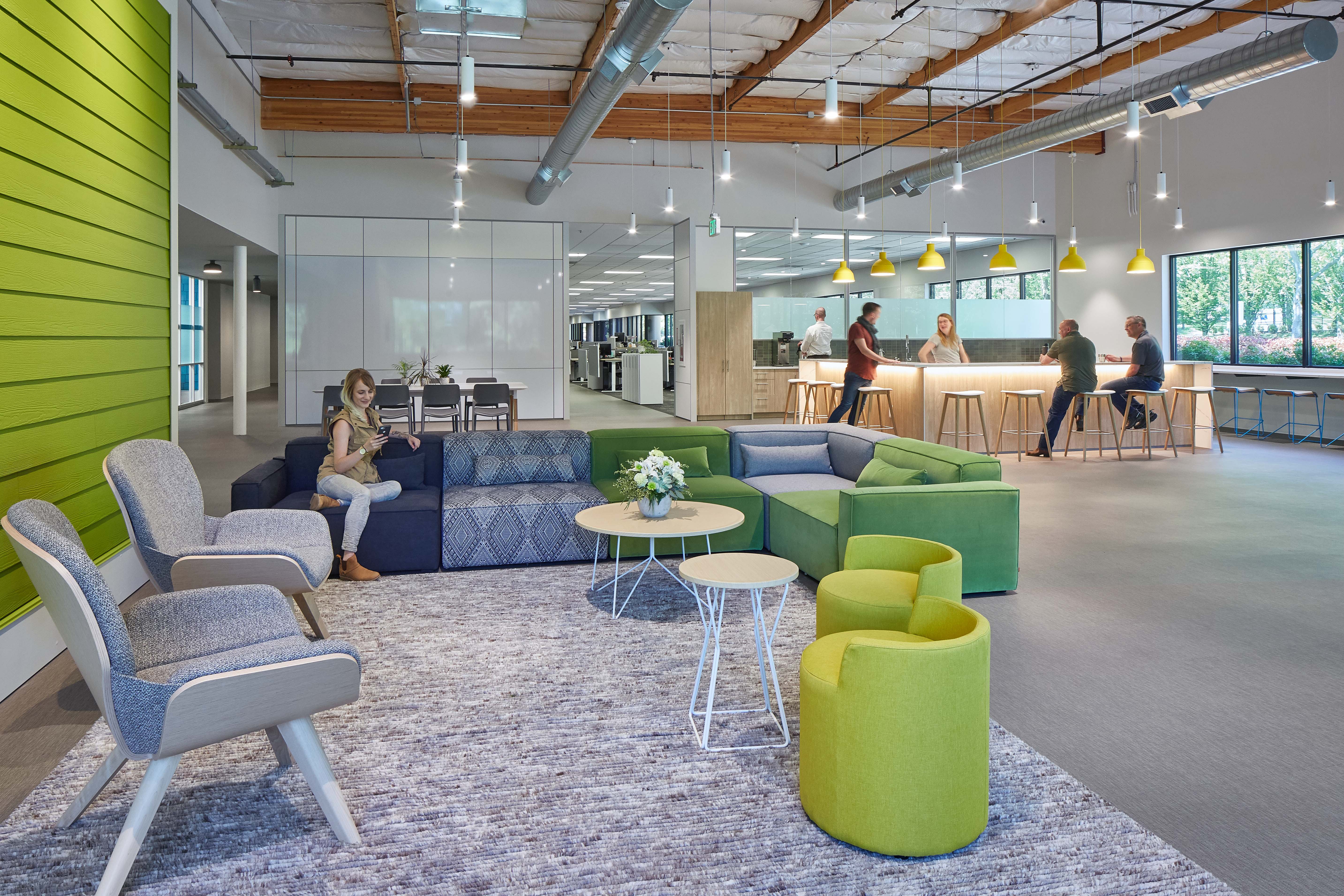 A beautiful open office space uses DIRTT's modular solid and glass walls to divide working and casual areas.