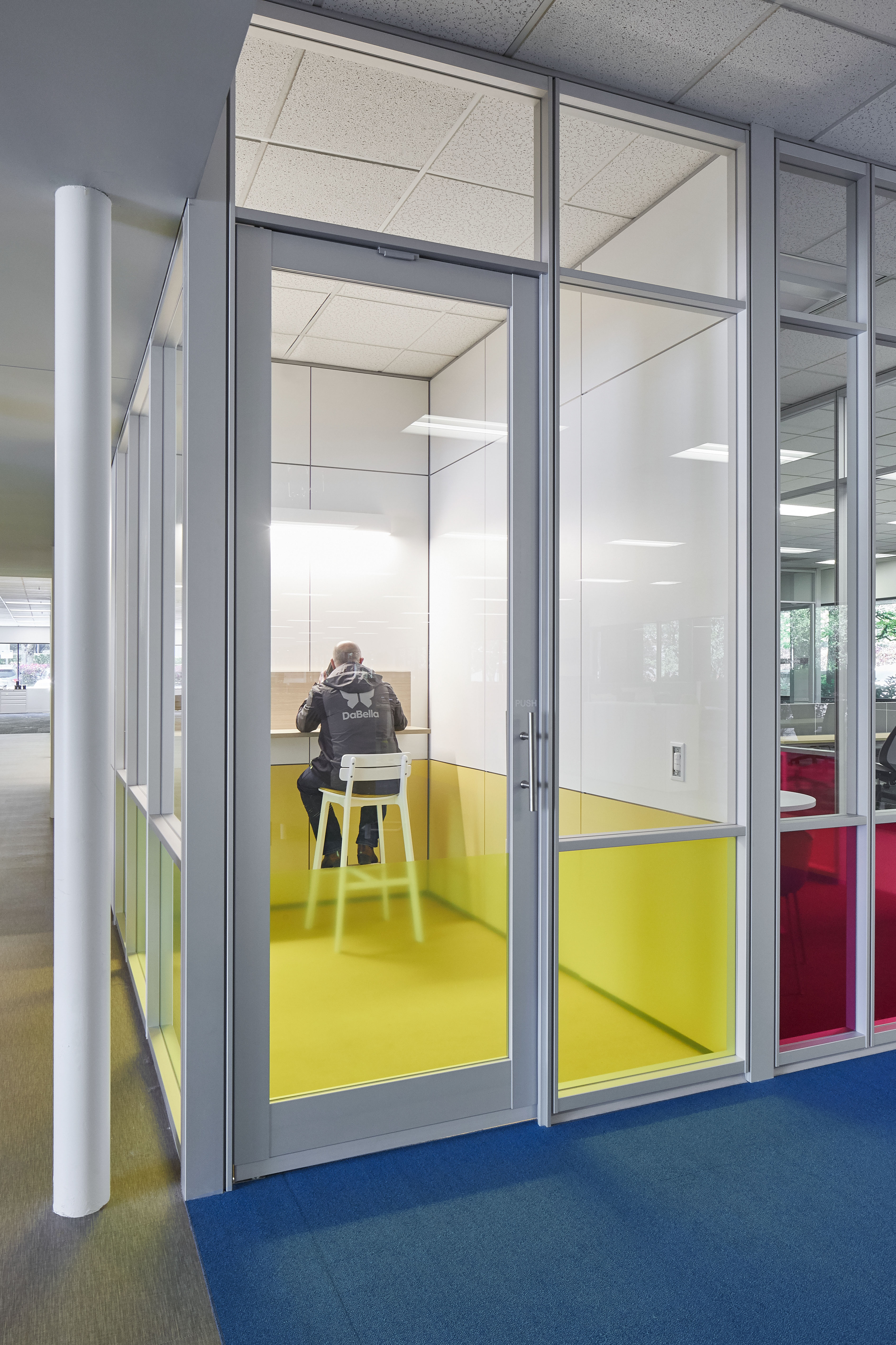 This private phone room is made from DIRTT's modular glass and solid walls and glass pivot door.