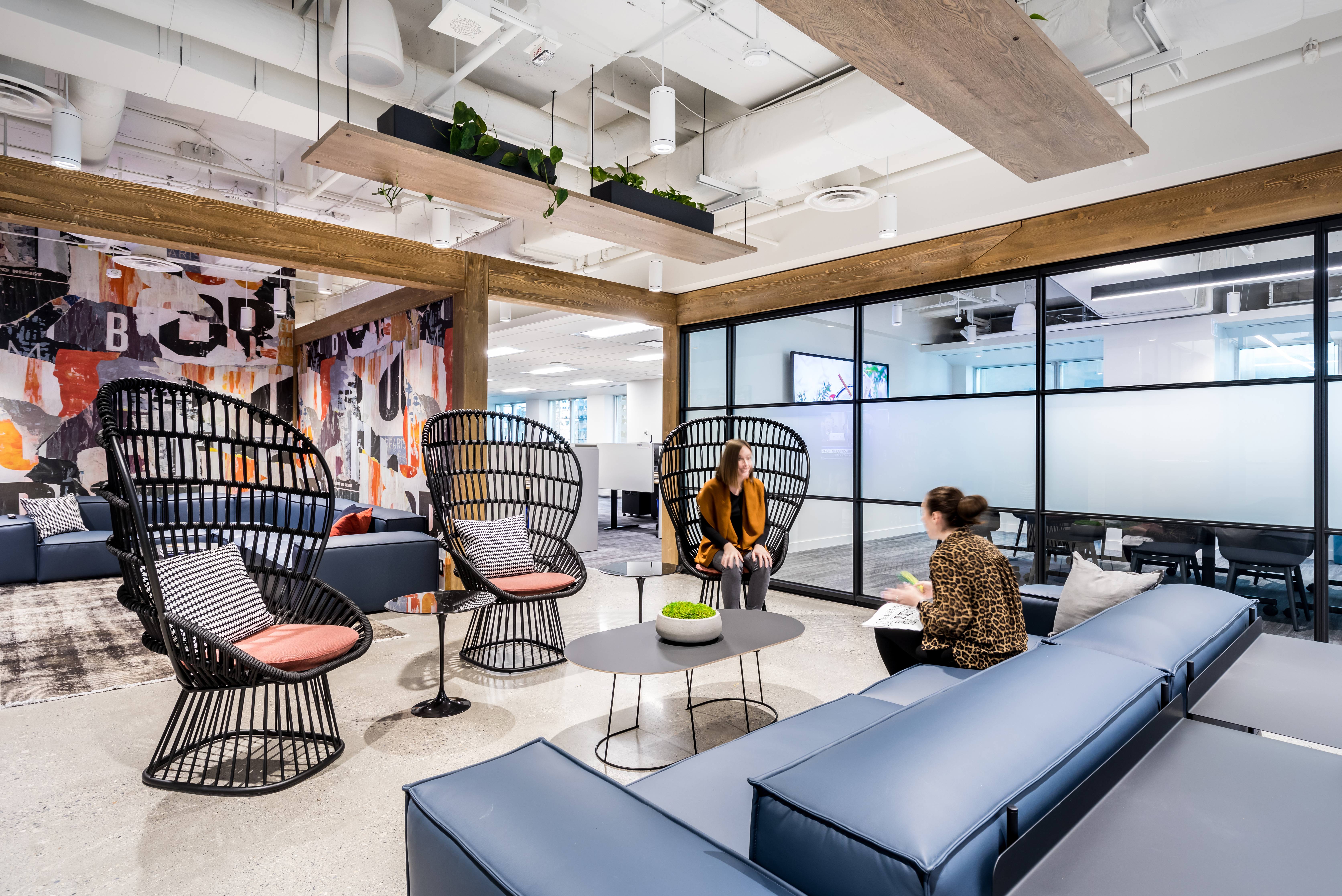 DIRTT's Timber Frame and center mount modular glass wall system flank a casual office meeting space.