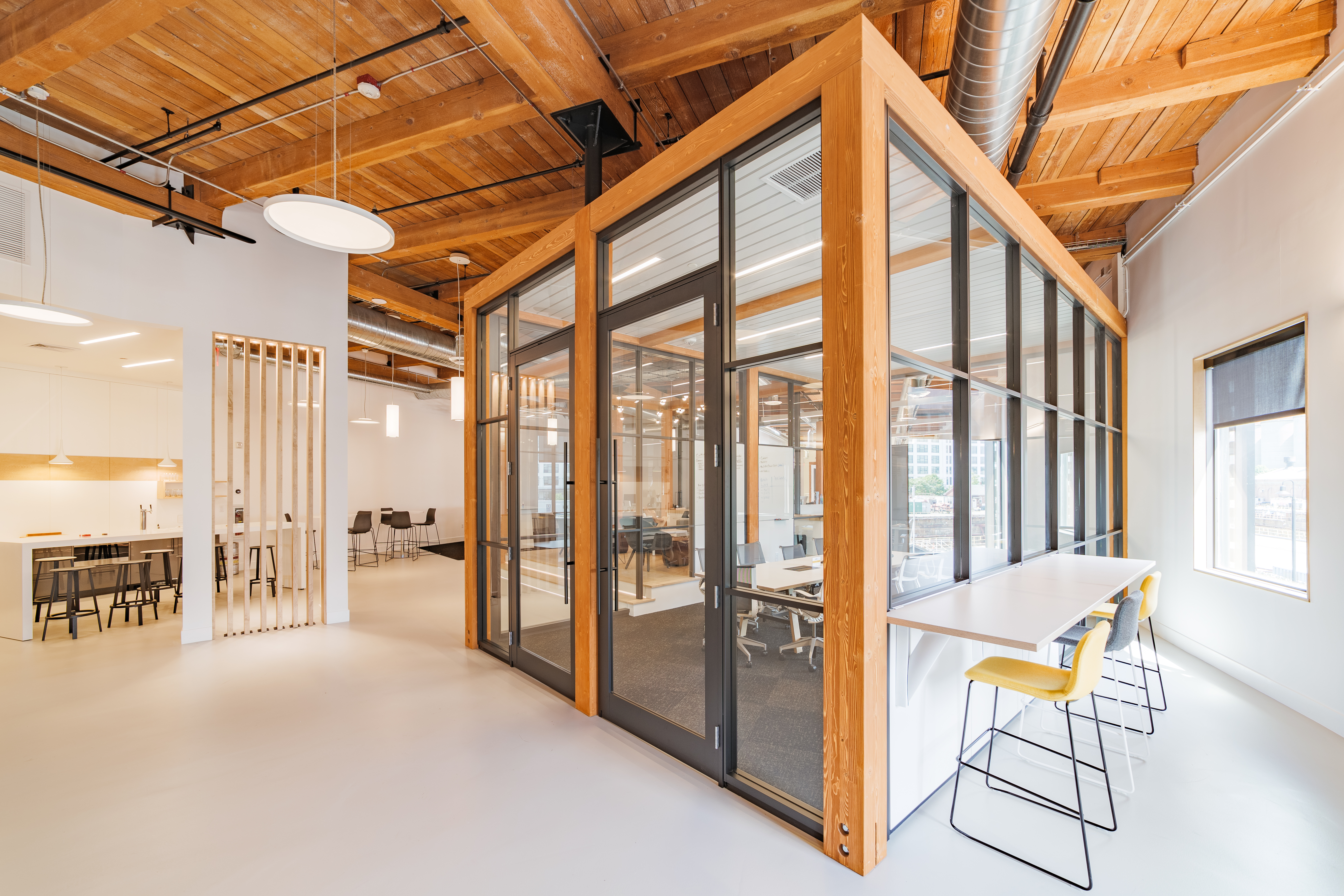DIRTT's Timber Frame surrounds this free standing meeting room made from a modular glass wall system.
