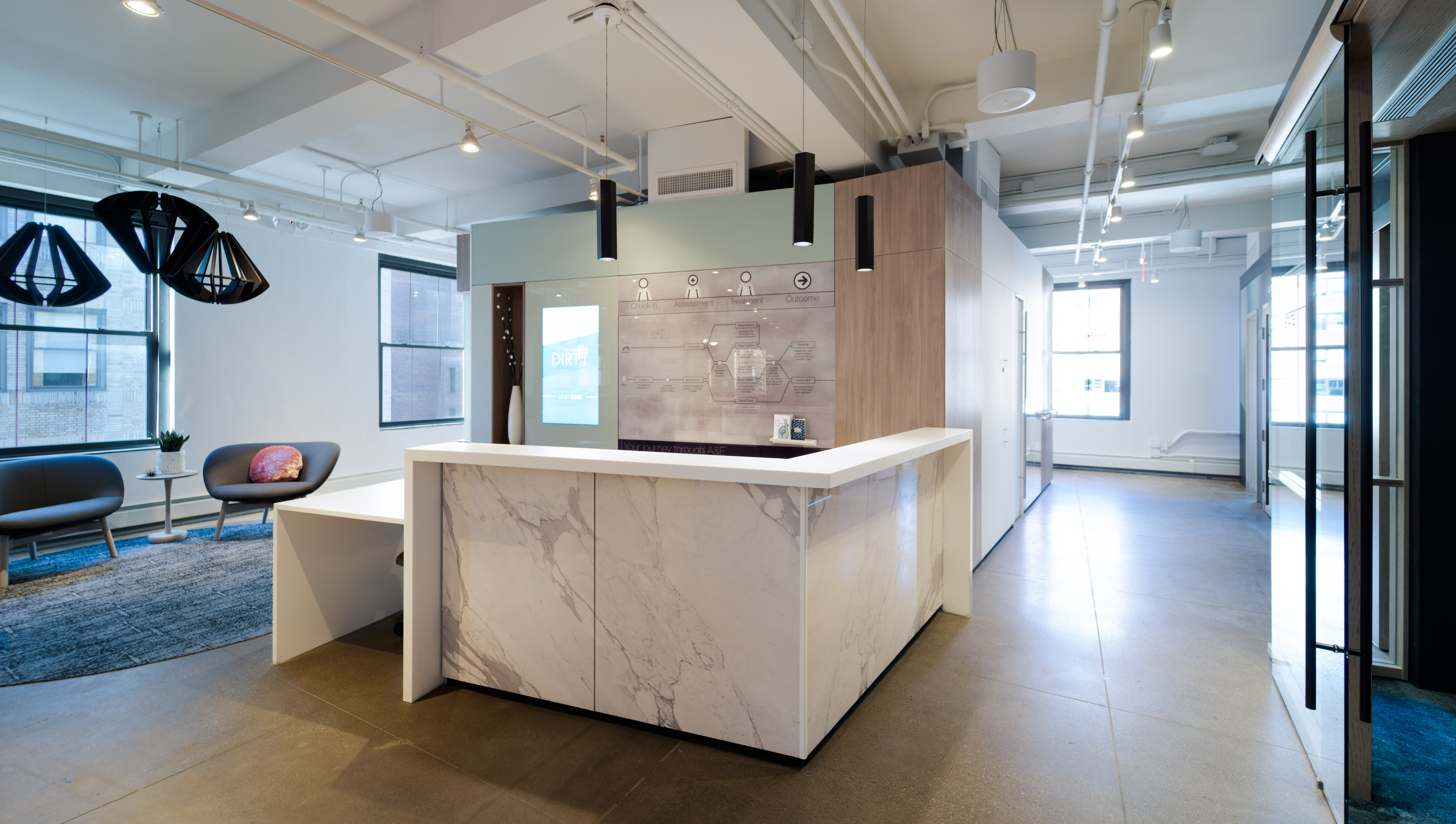 The solid DIRTT wall behind this reception area features custom graphics, veneer panels, and an integrated display.
