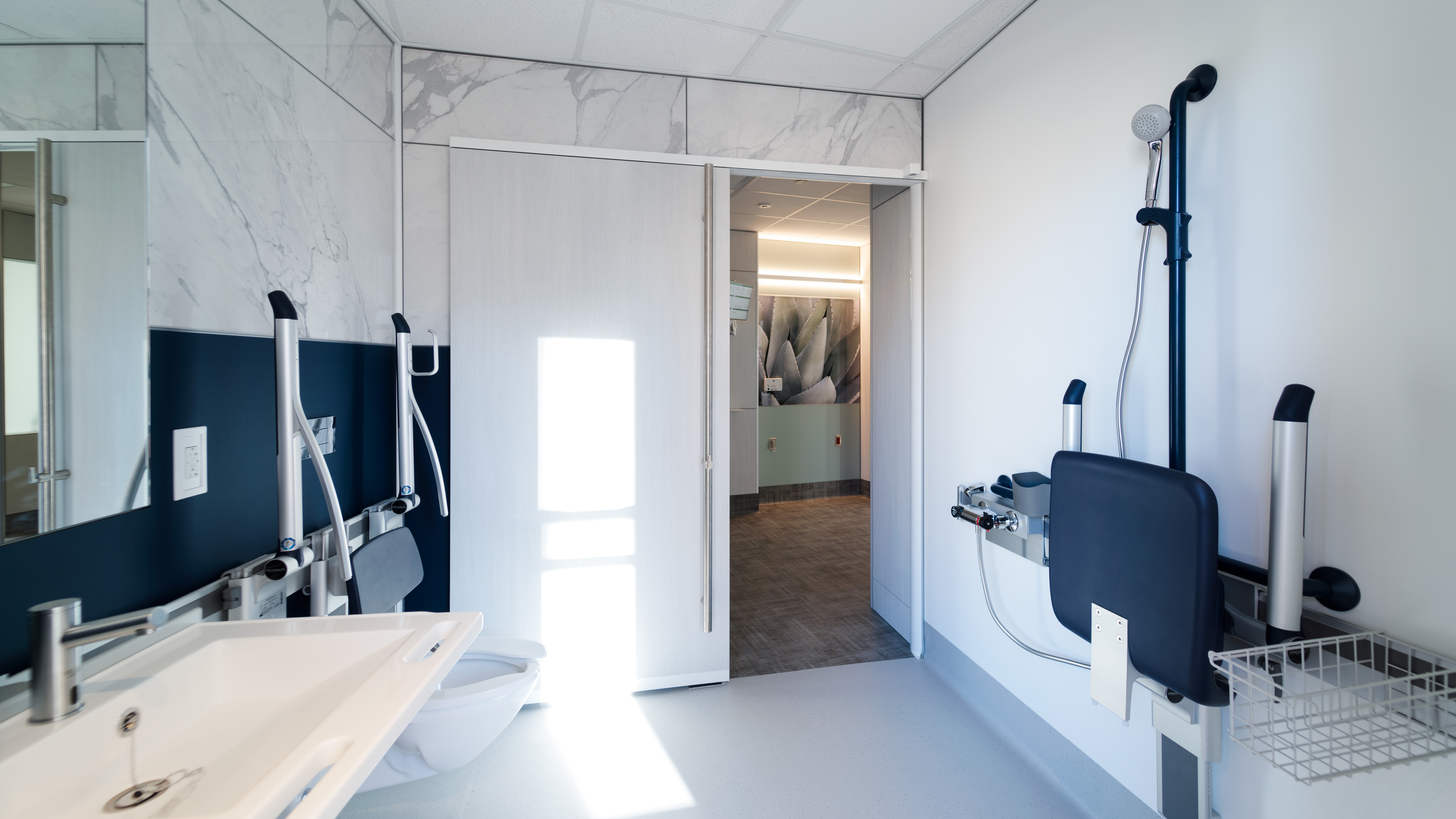 This patient washroom has a sliding barn door and custom graphics that resemble marble.