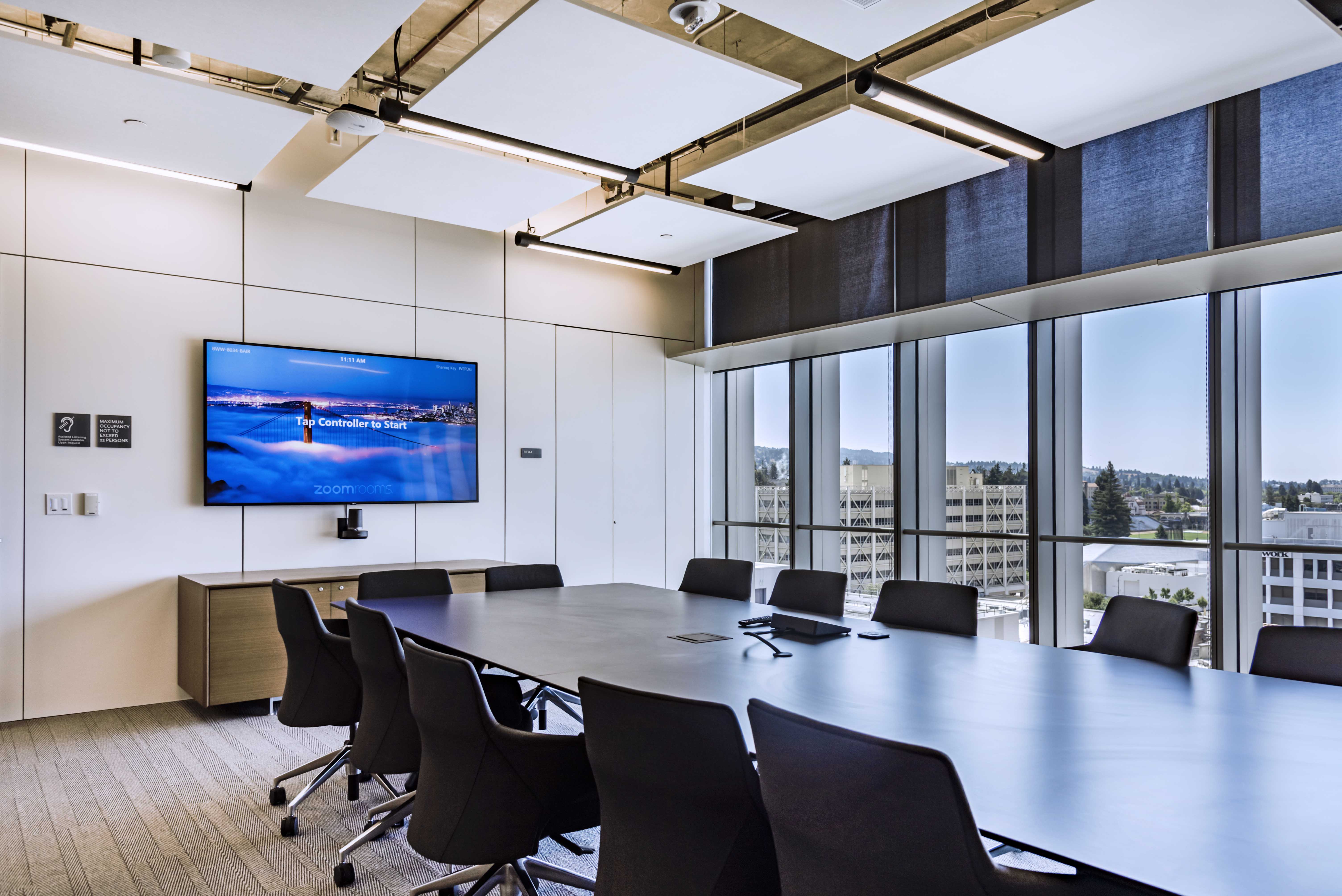 College research lab meeting room with prefab solid walls, overhead cloud panels, and integrated technology