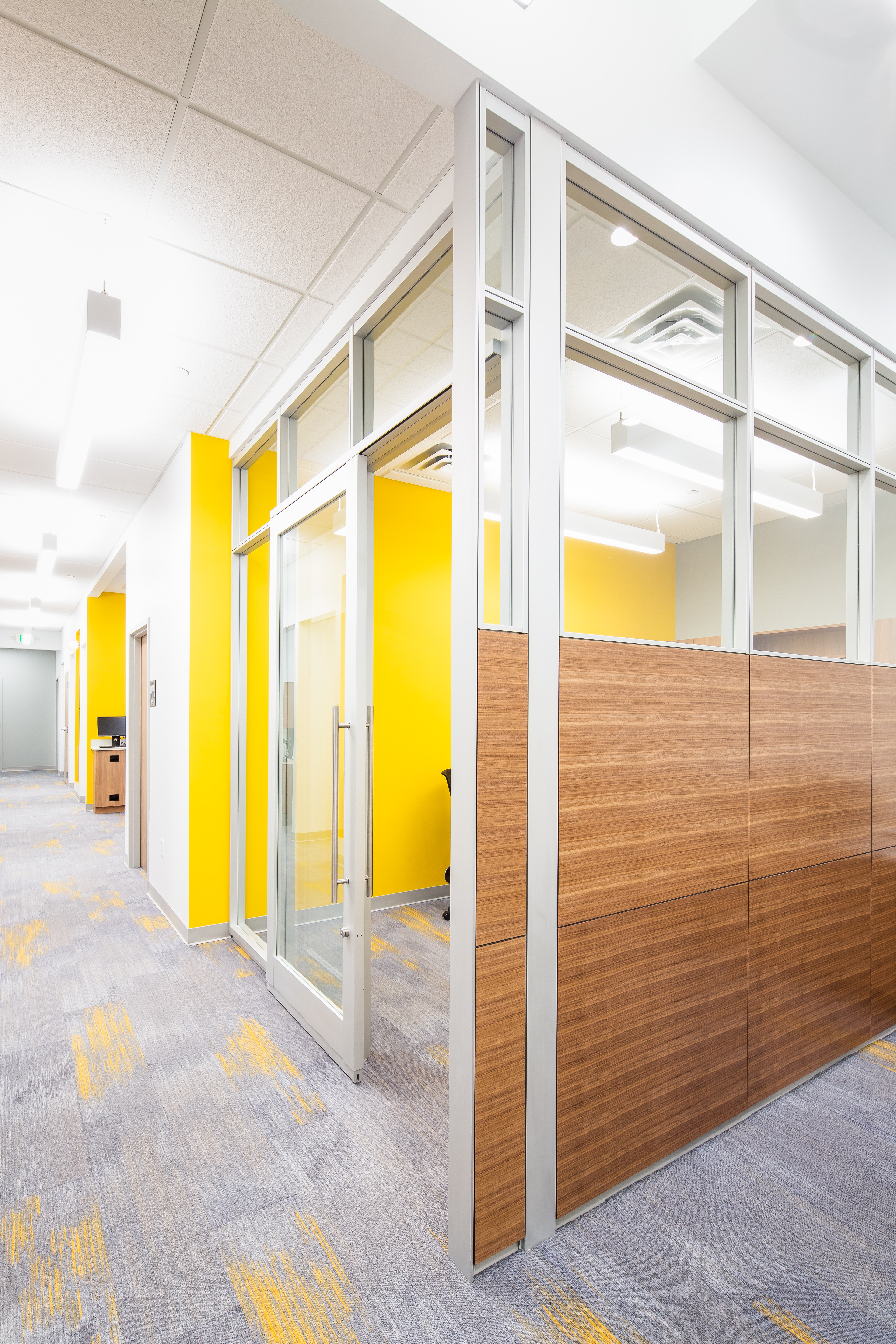 This private meeting room has combination glass and solid modular walls and a glass sliding door.
