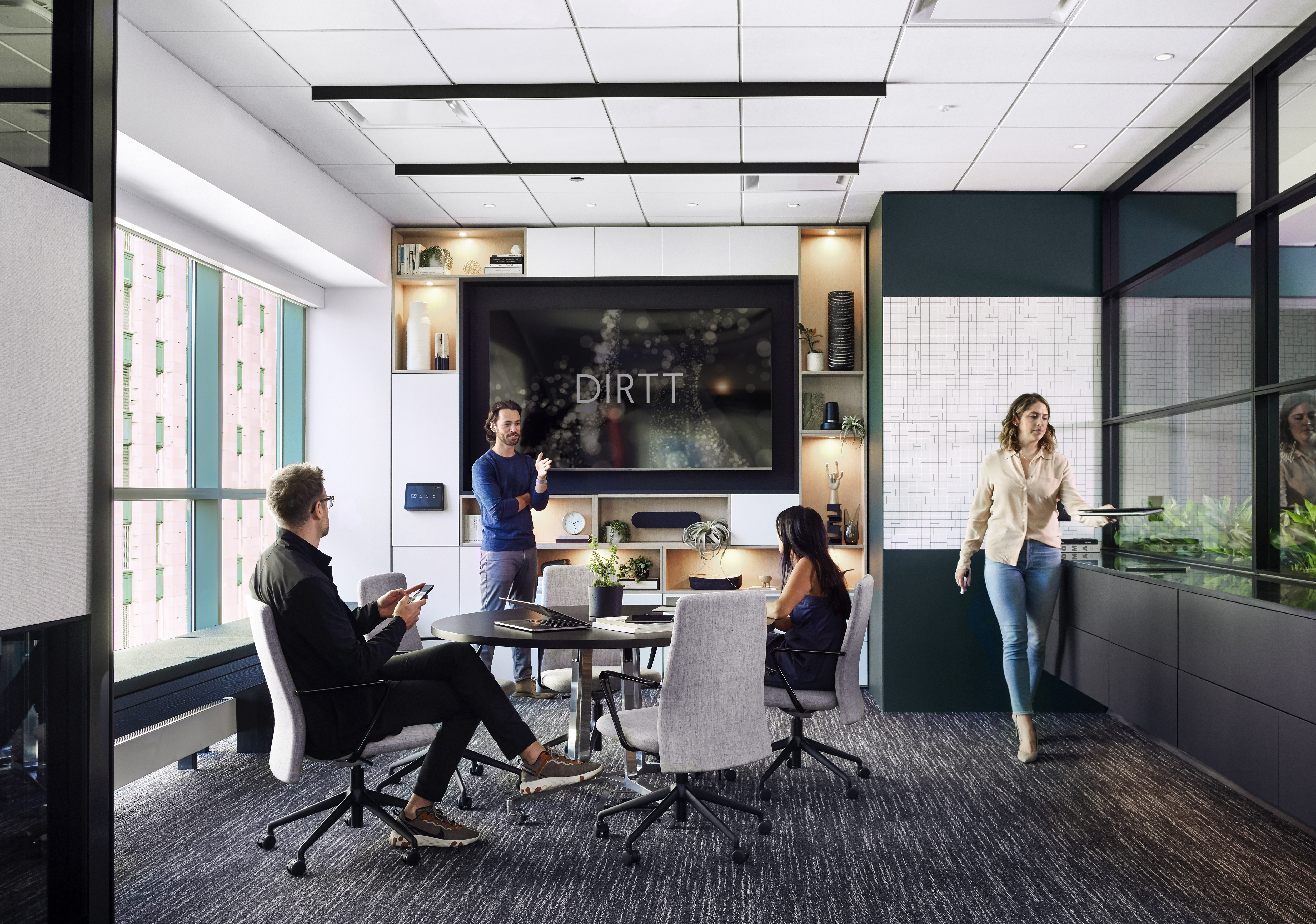 This meeting room has a custom casework shelving unit to house a large screen and casework drawers along one wall.