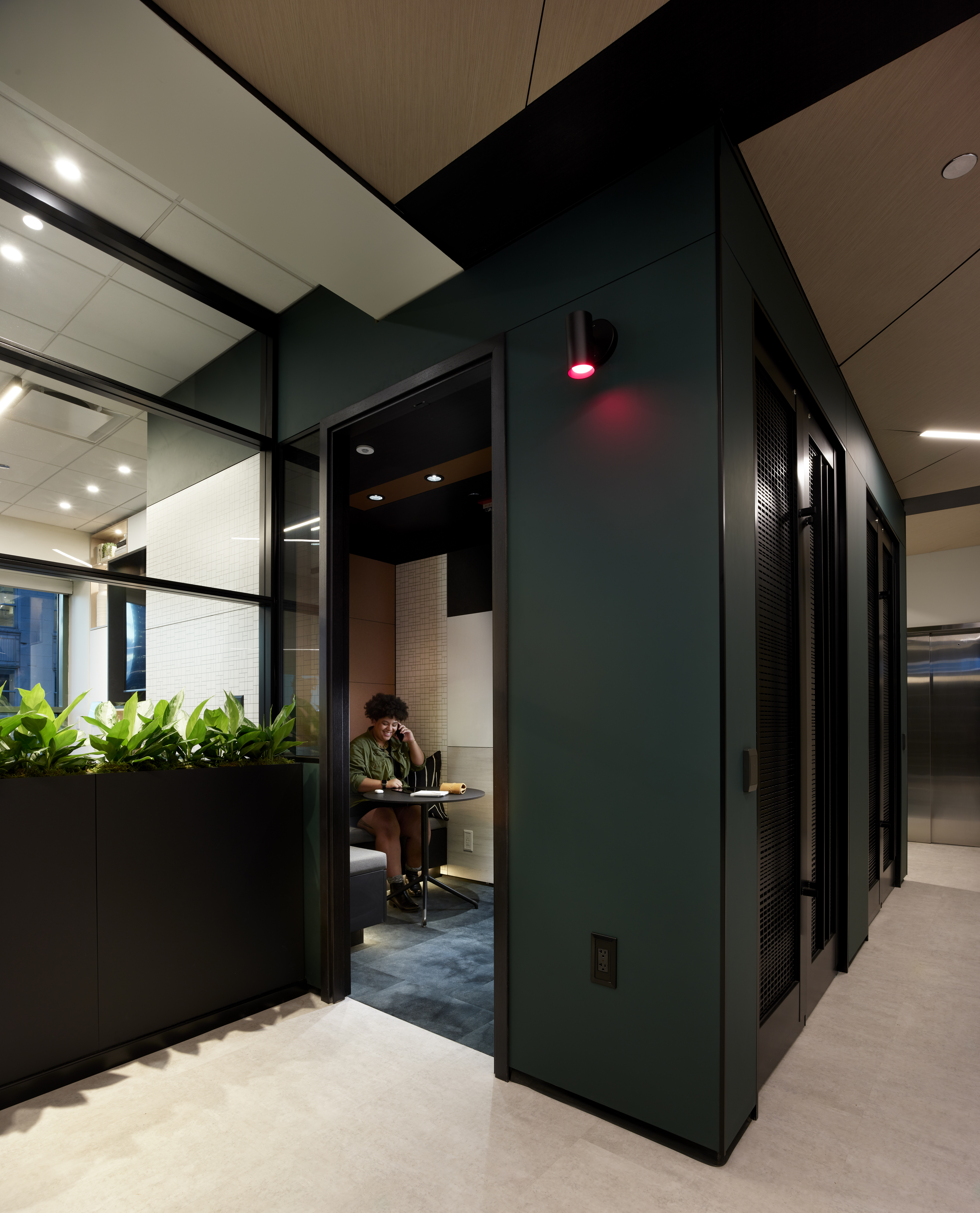 This private phone booth area has a center mount glass wall to let in natural light.