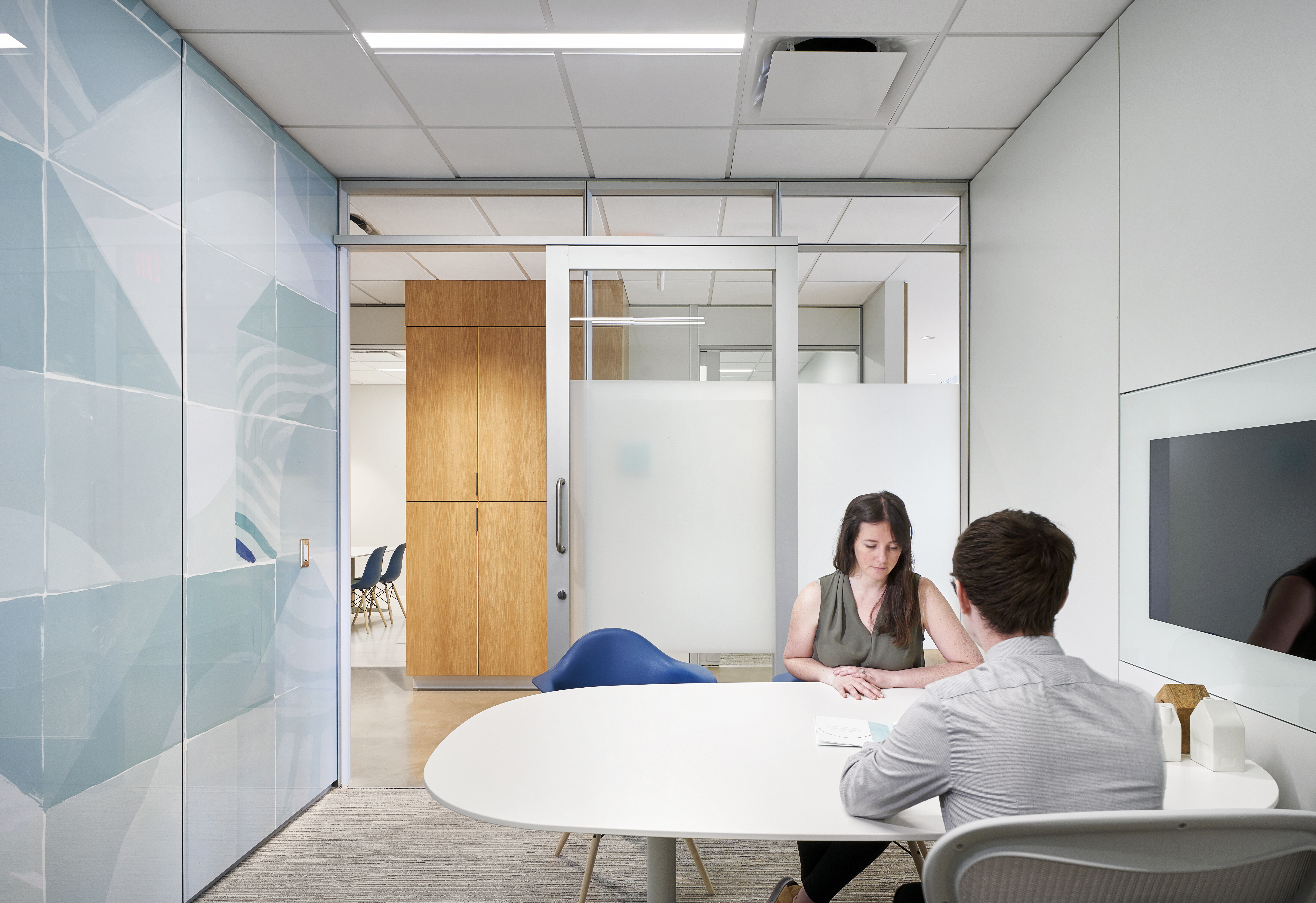 Inside this meeting space made from DIRTT's modular glass and solid walls are custom graphics and integrated technology.