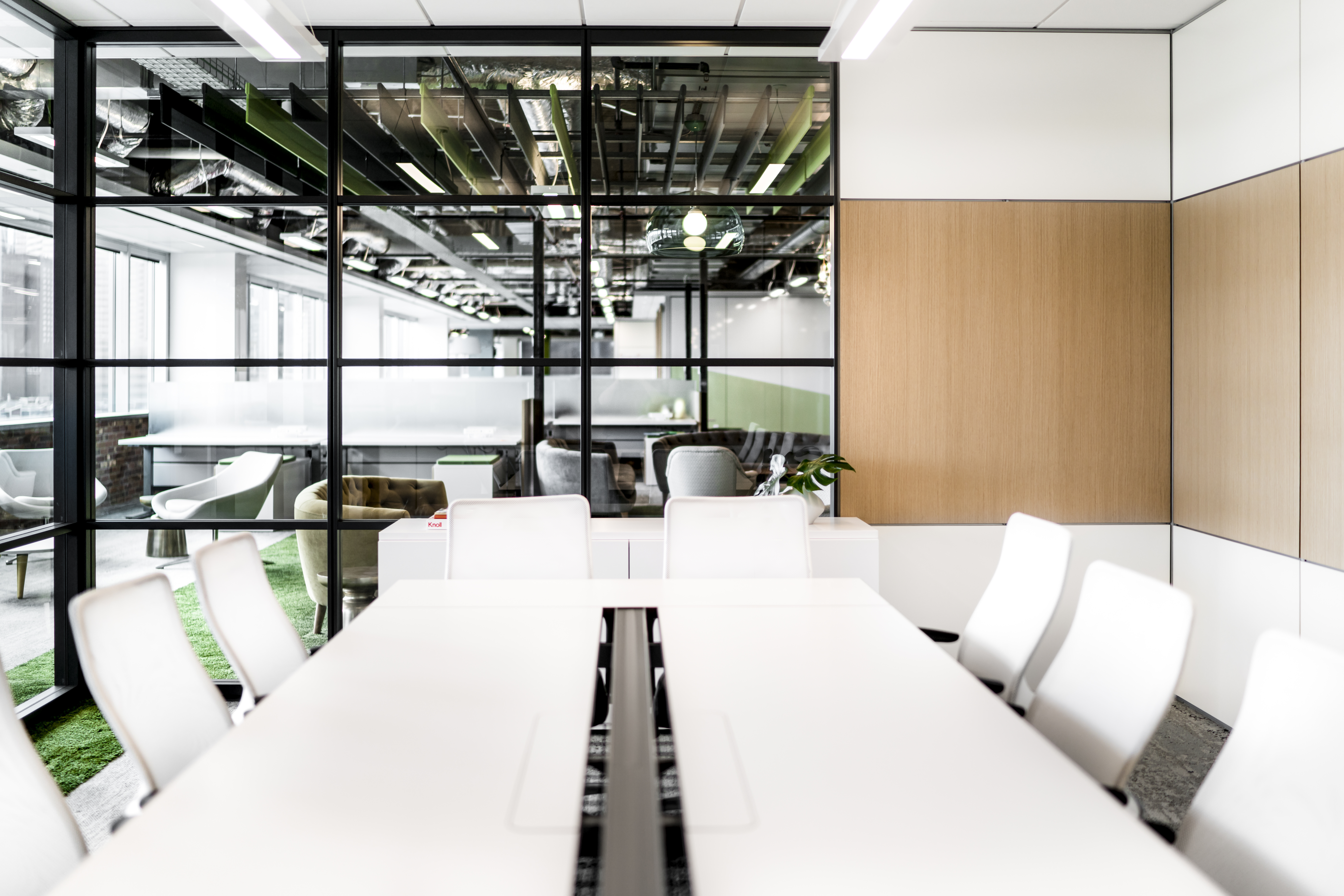 This large meeting room has stacked glass and solid modular walls from DIRTT with custom veneer panels.