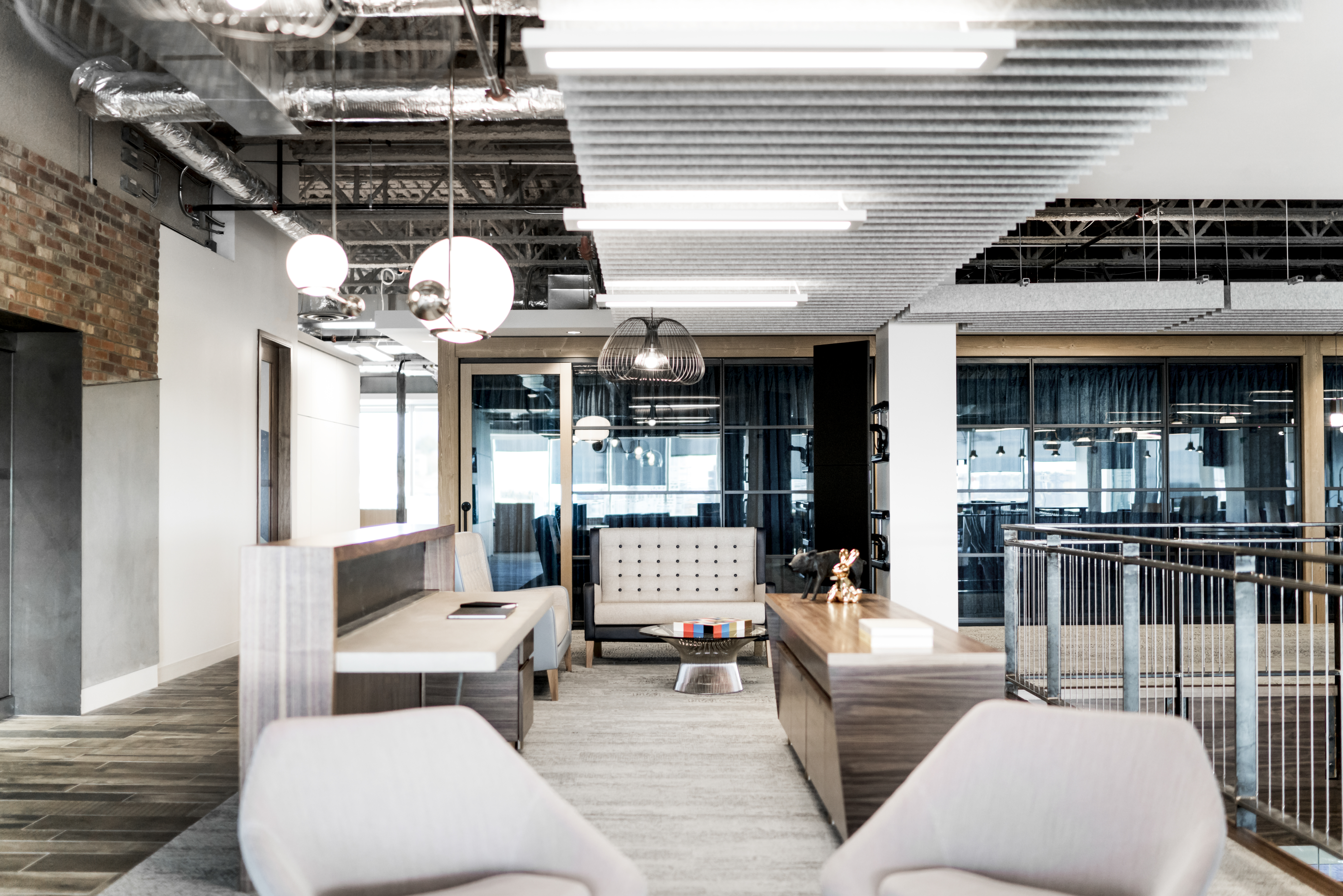 Stacked glass wall from DIRTT are visible in the meeting rooms behind this open seating area.