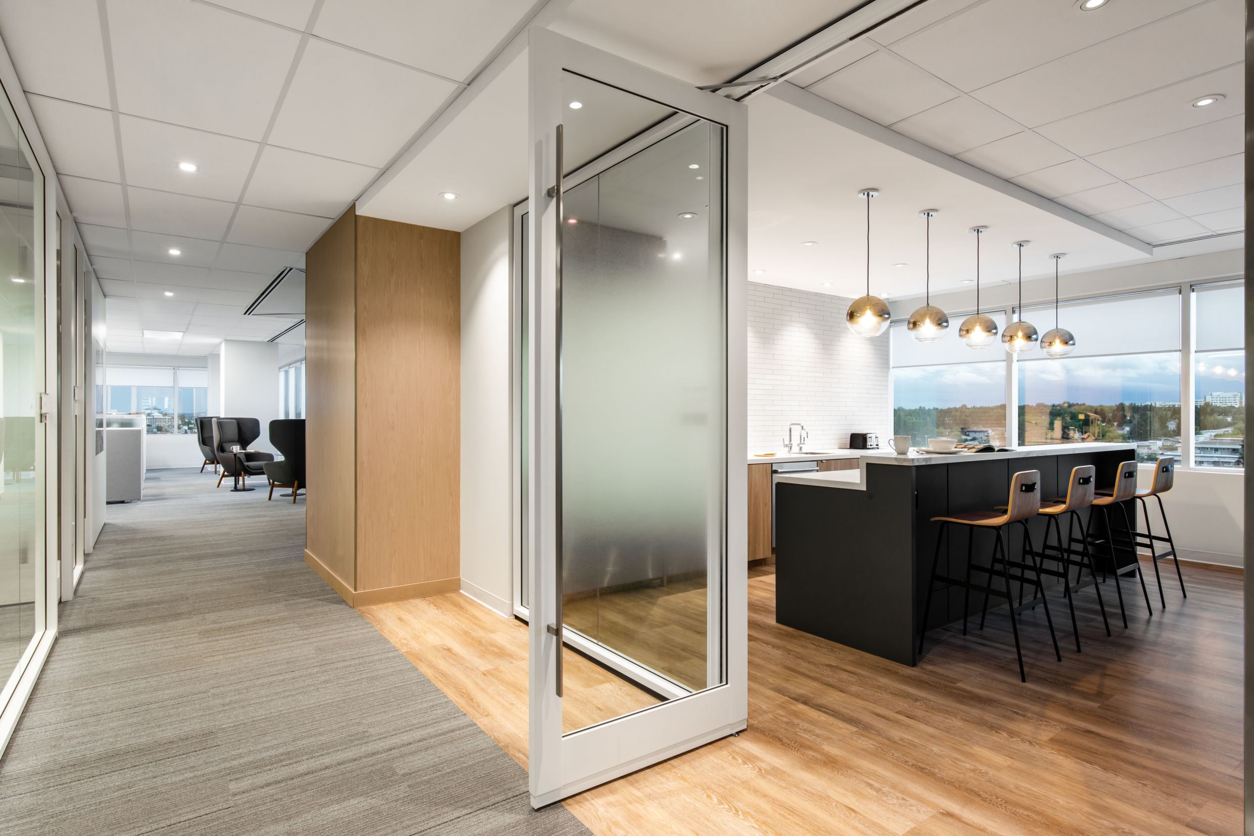 Pivoting interior door integrated with glass walls in a common are