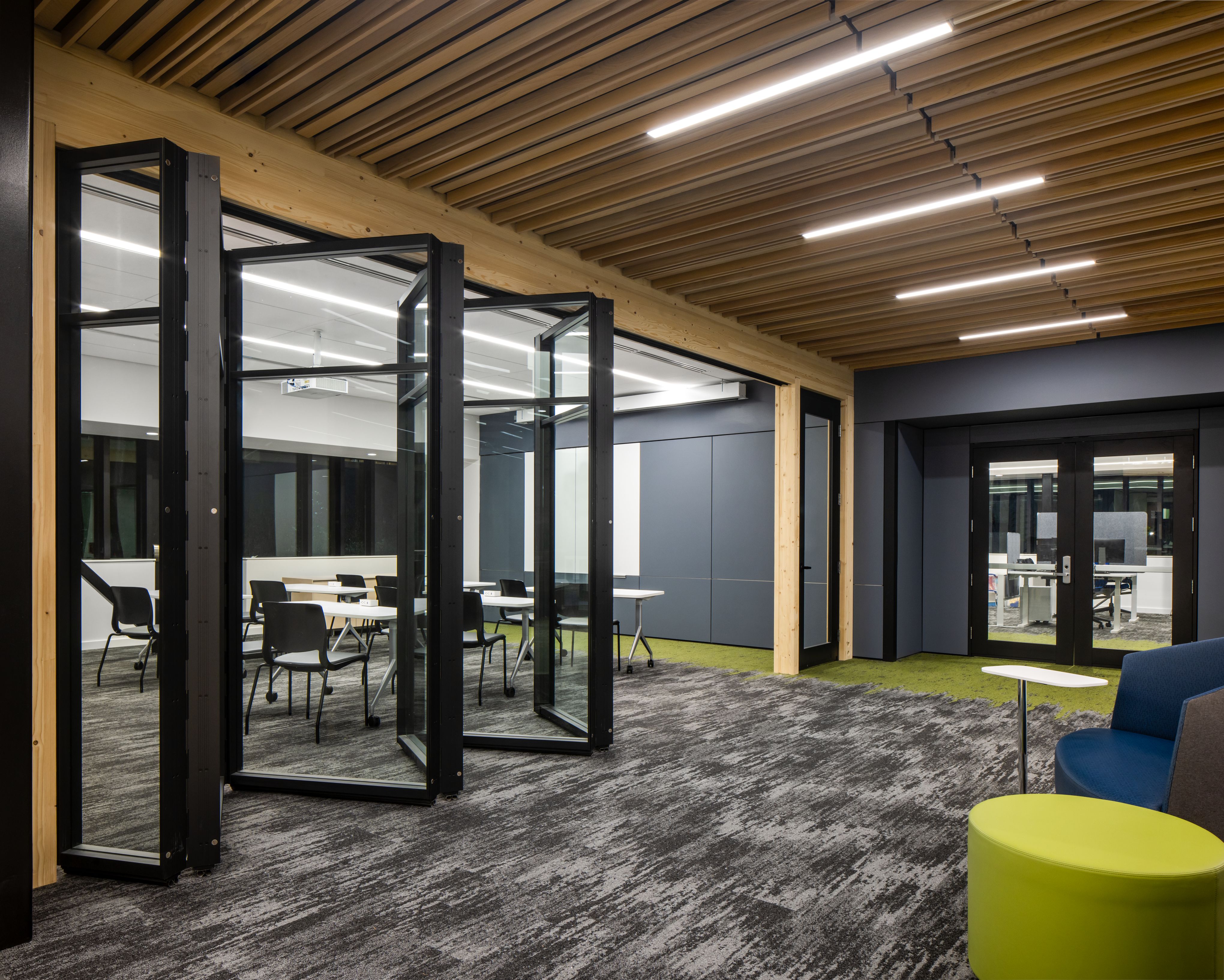 Folding glass wall system with a black frame shown open