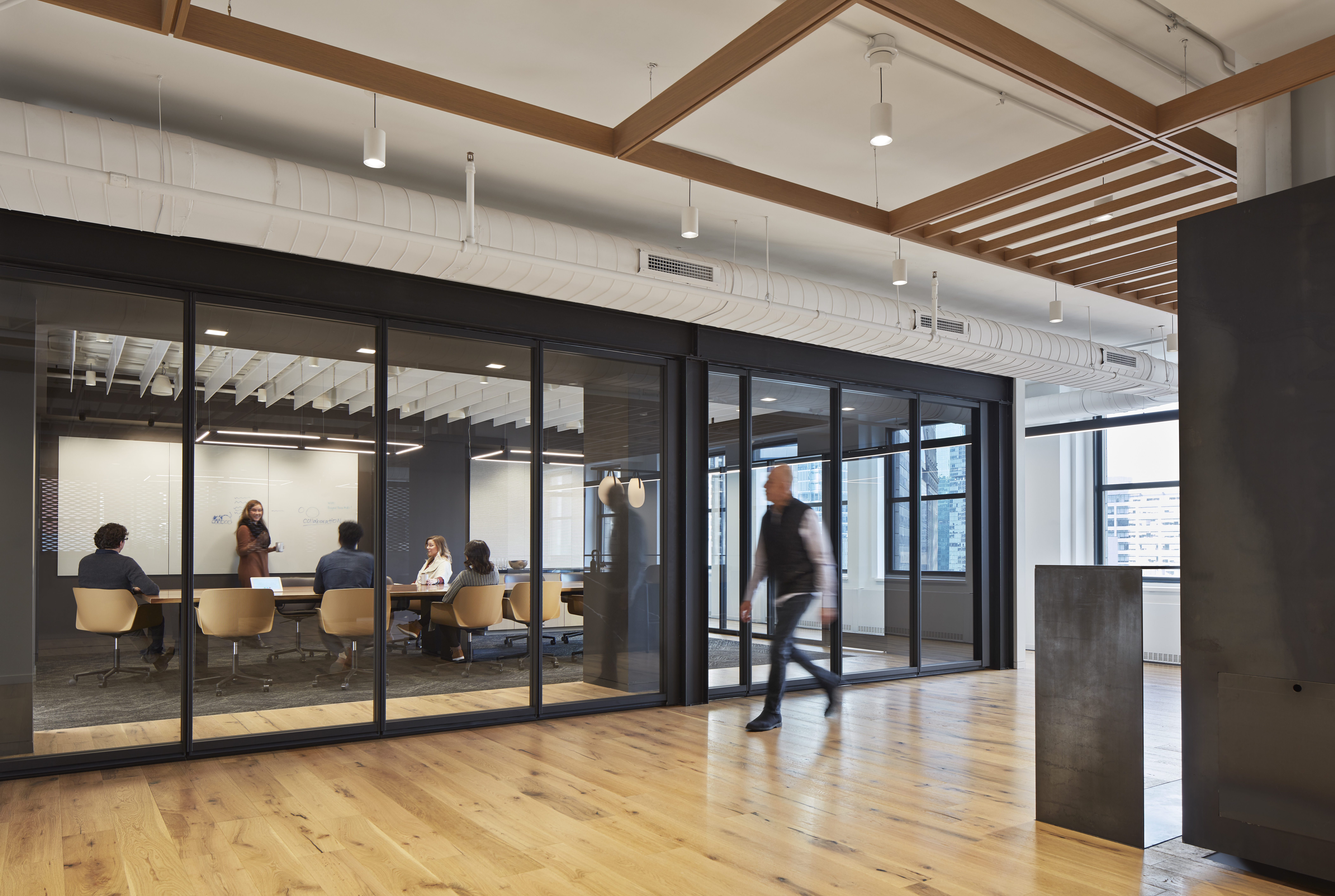 Folding glass wall system shown closed to a meeting room