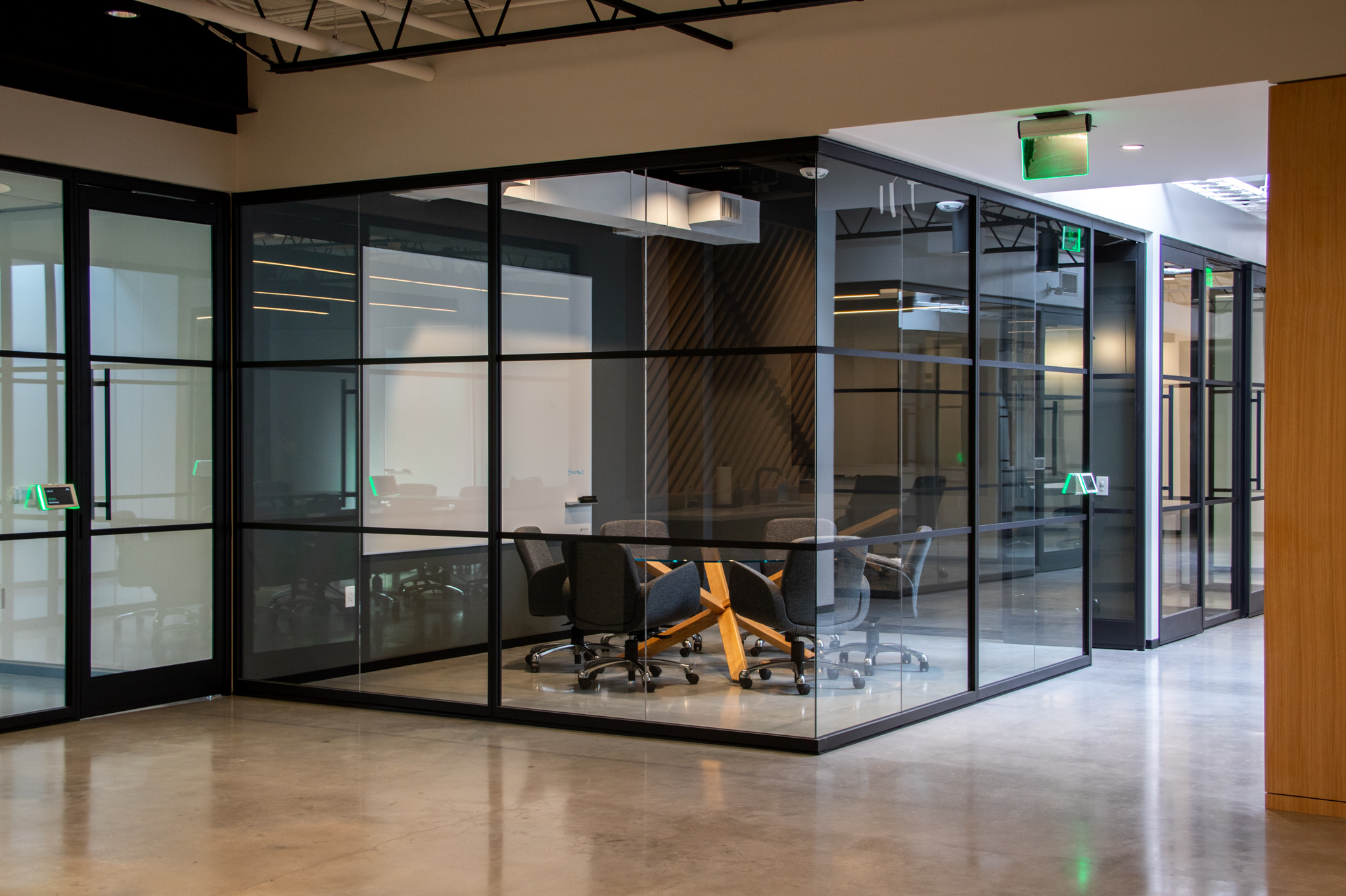 Image of office space with interior rooms made up of modular glass wall panels with black framing for a clean aesthetic