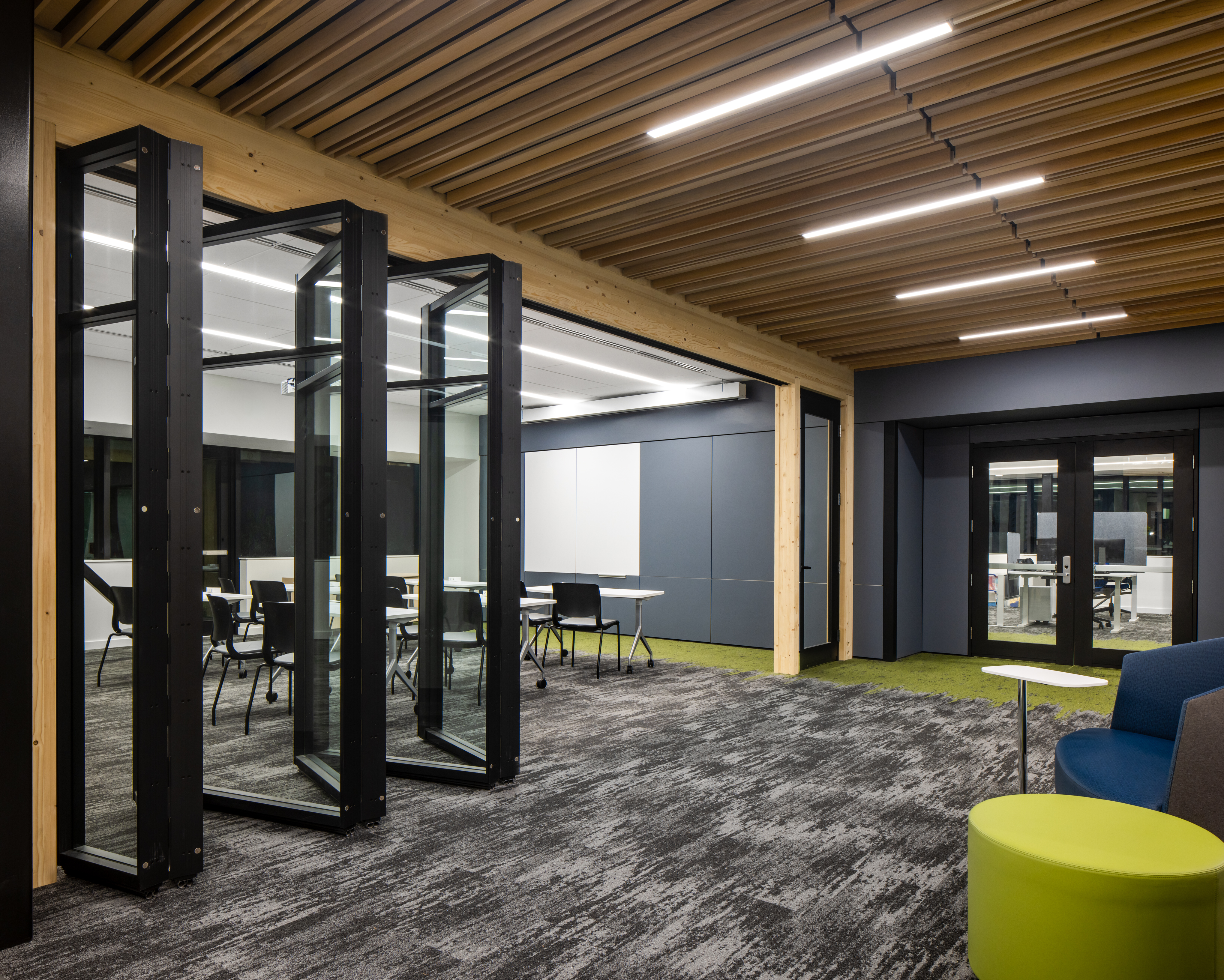 College student center with folding walls dividing rooms underneath timber ceiling