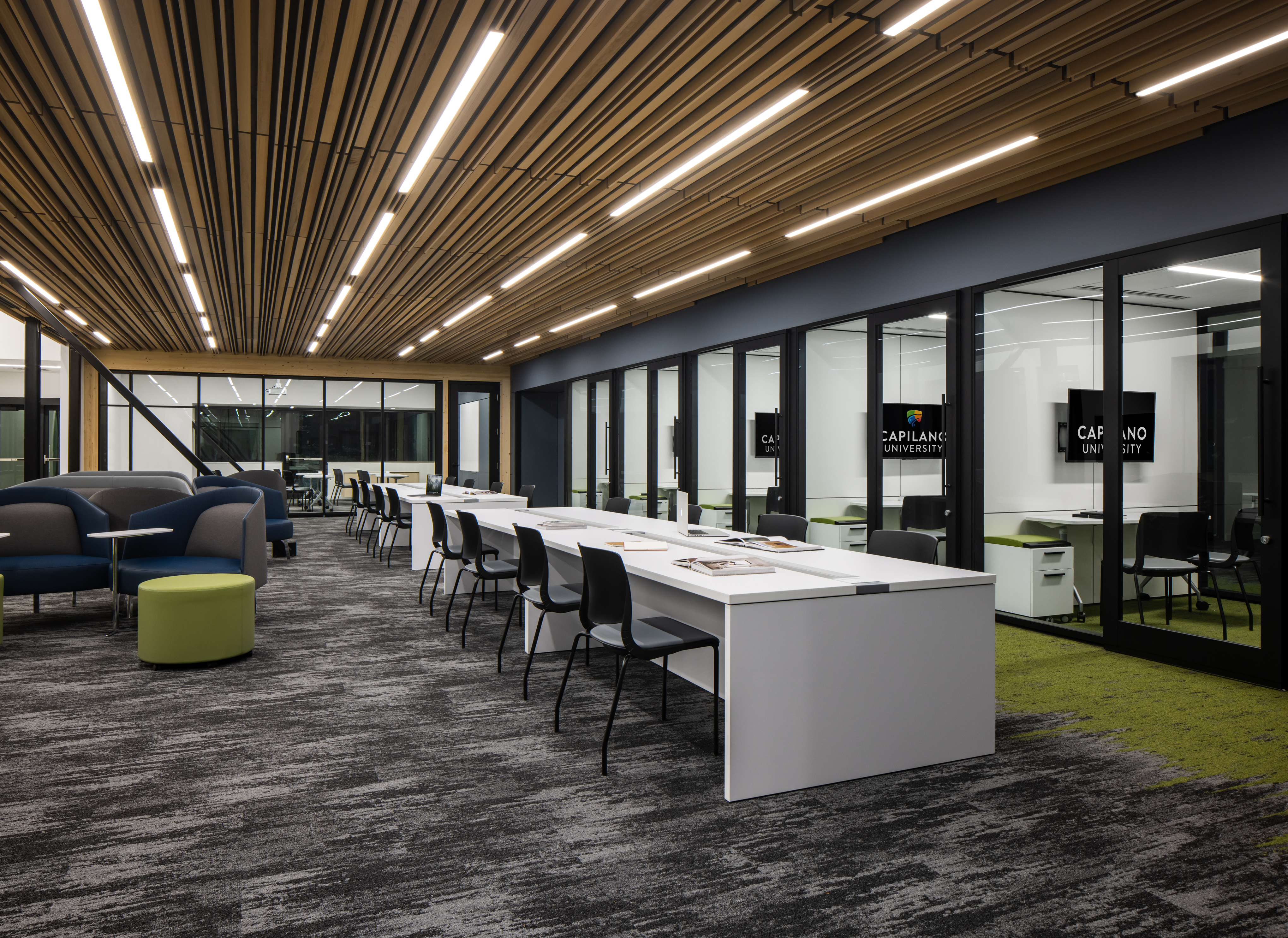 University campus student center built with prefab double pane glass walls, integrated technology, and timber overhead