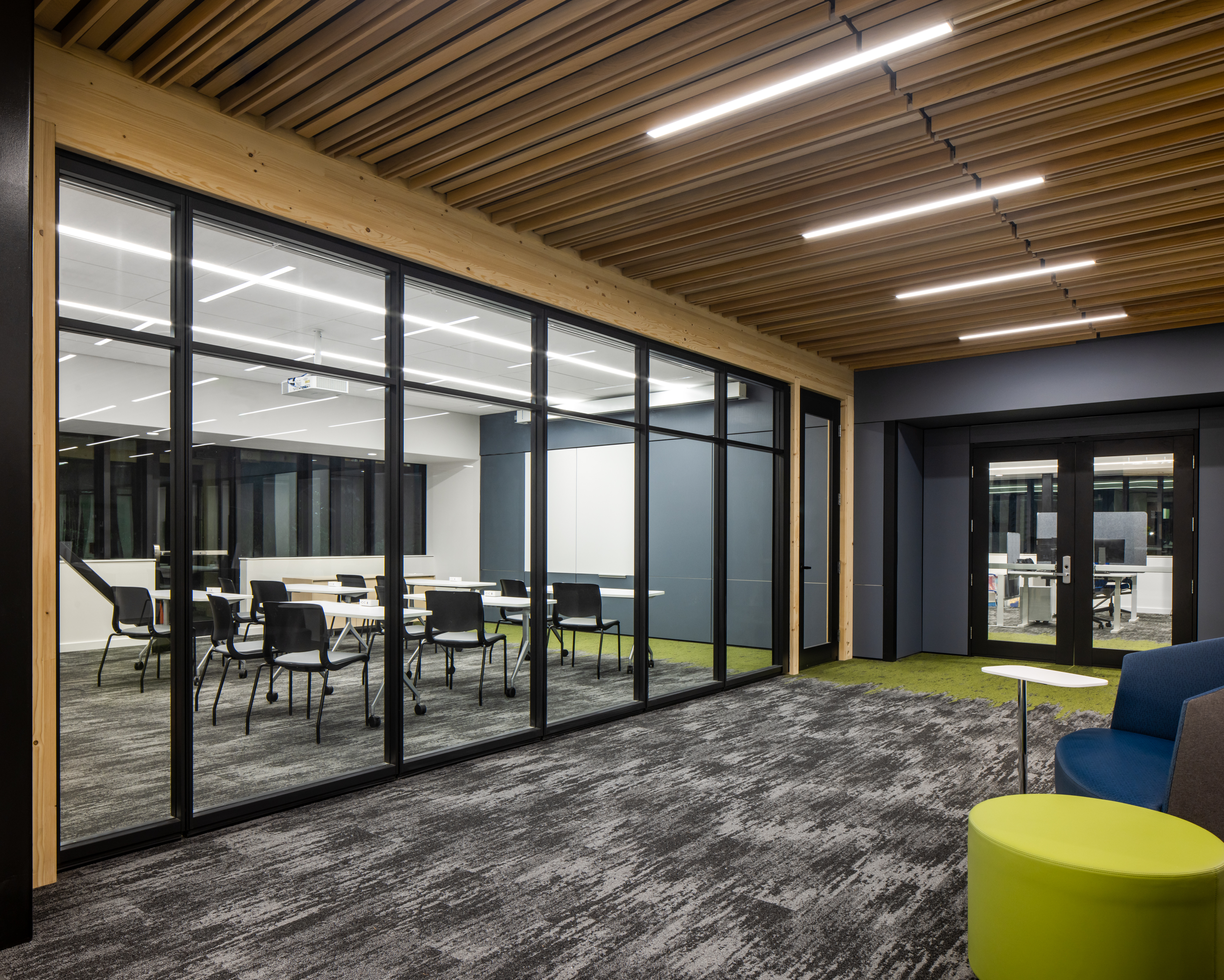 Higher education conference room behind prefabricated solid glass walls and under timber ceiling