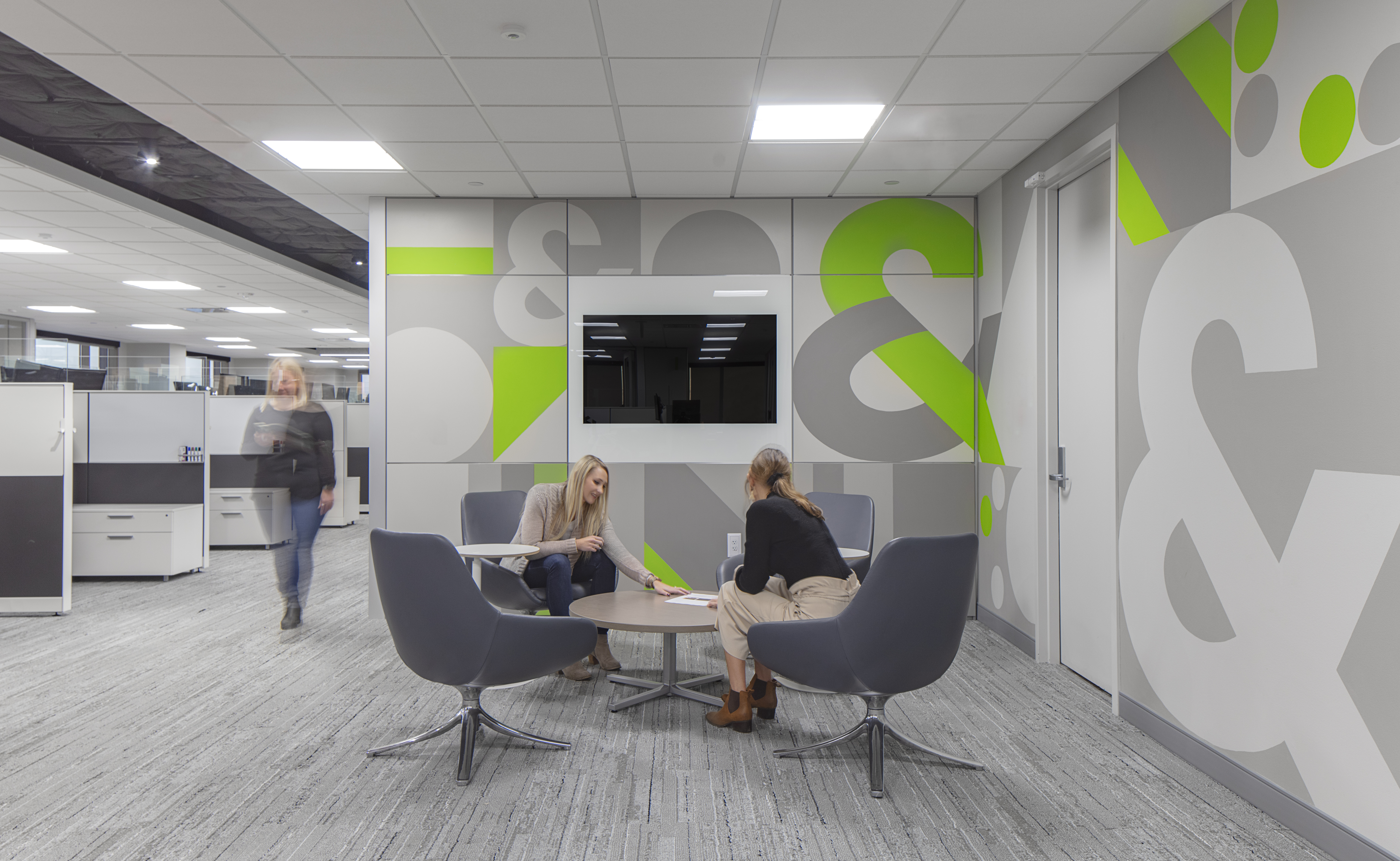 Modular solid walls shown with graphic wall panels and integrated technology shown in a collaborative office space