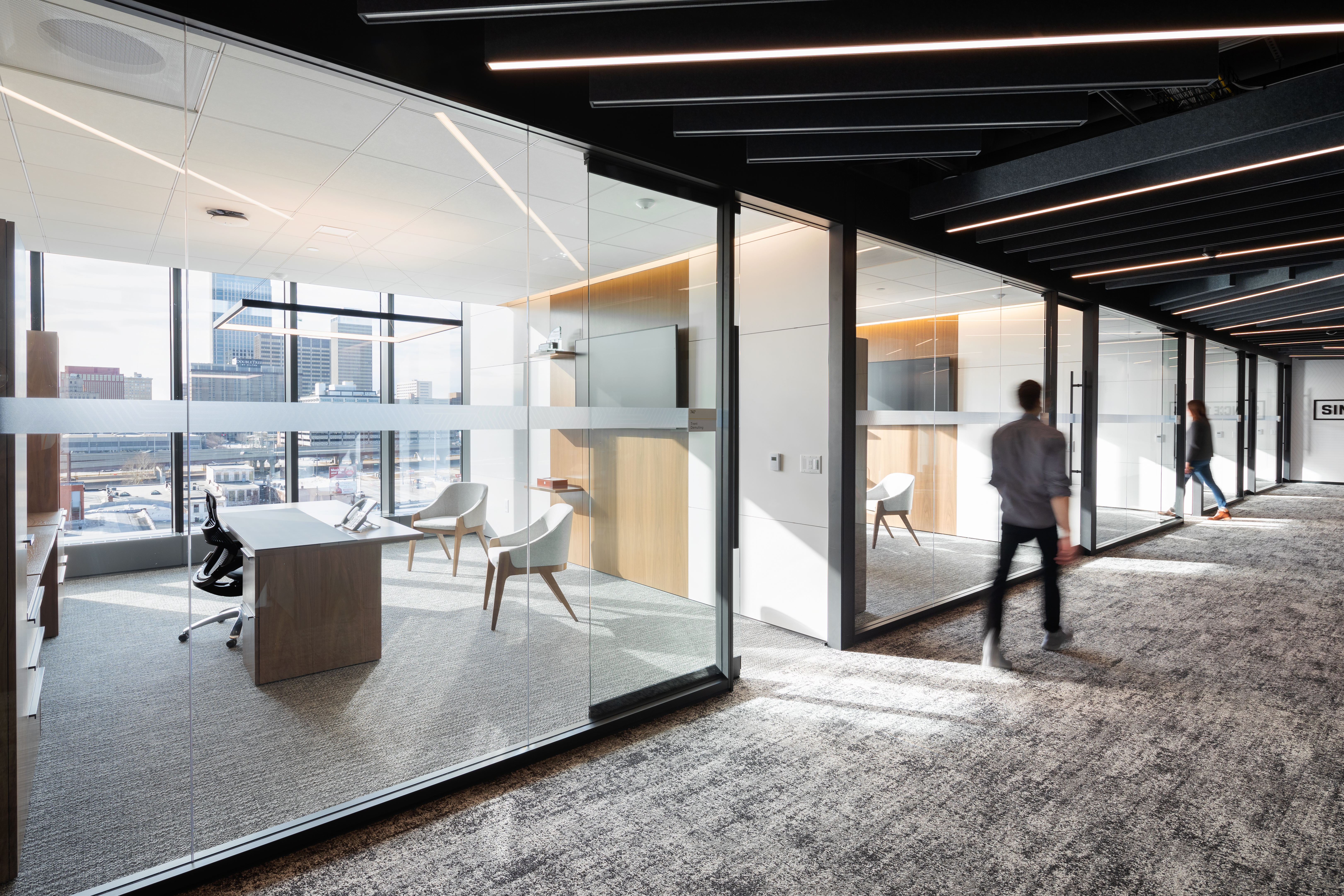 Image of two private offices with a large modular glass wall installation, letting the light in.